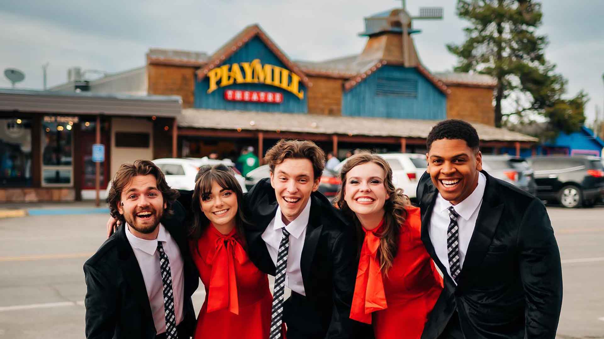 Playmill Theatre cast members smiling in front of the Playmill Theatre in Island Park, Idaho