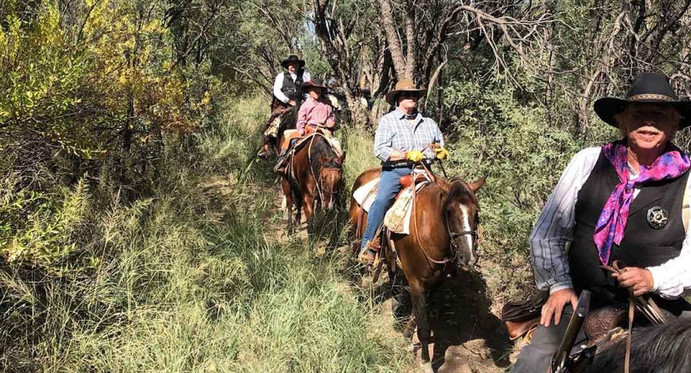 Guided horseback riders on wooded trail at Haviland's Old West Adventures in Island Park Idaho