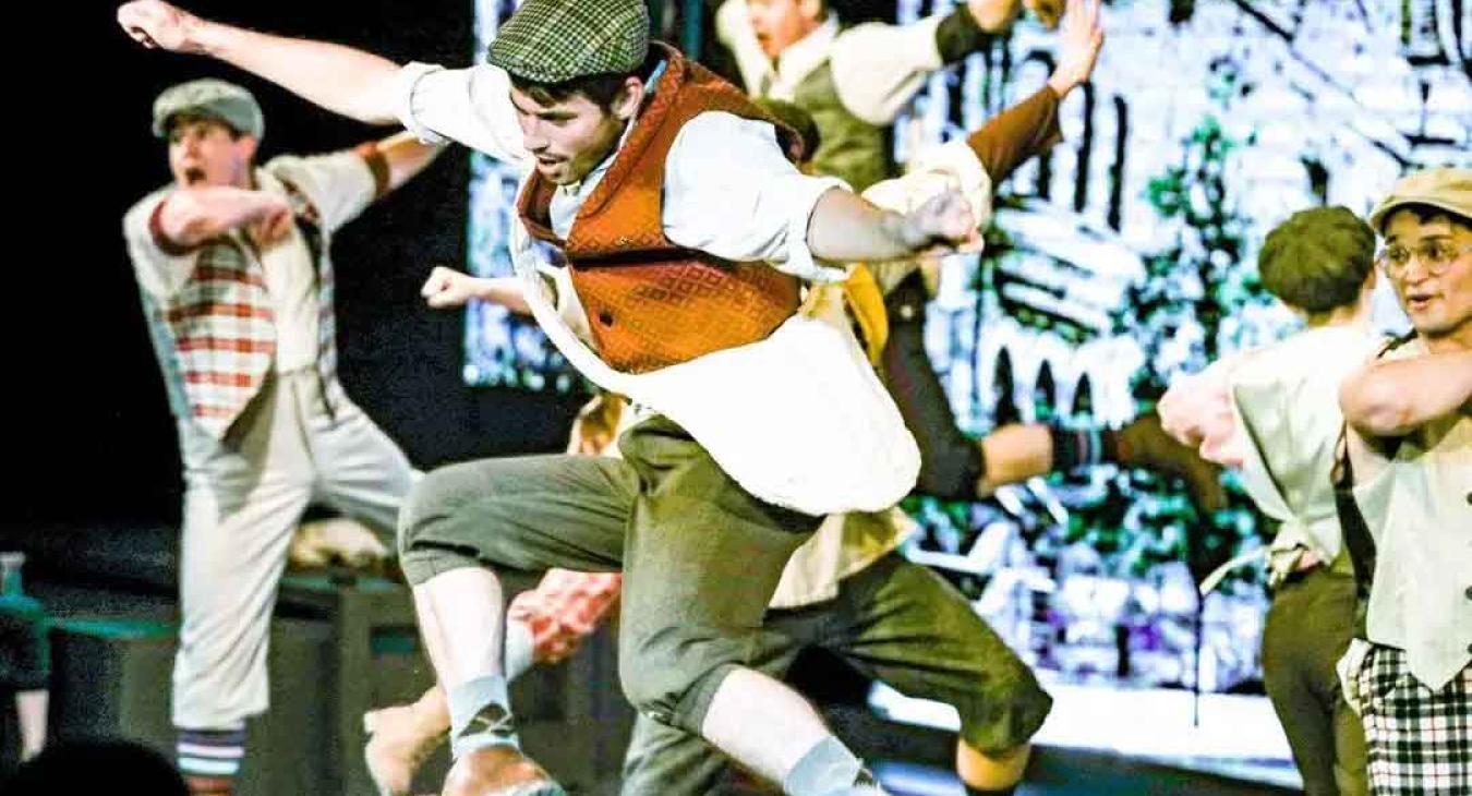 Playmill Theatre cast performing high energy dance number in Disney Newsies at Island Park Idaho