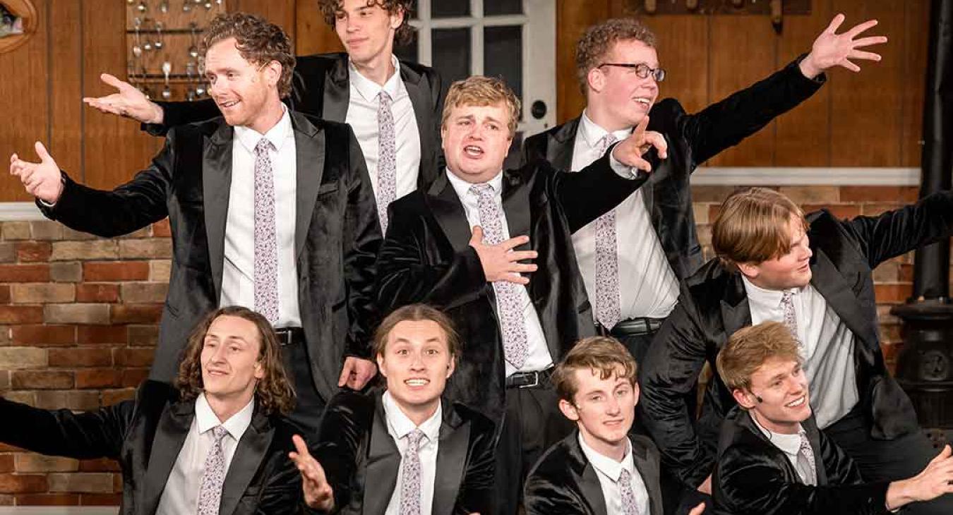 Playmill Theatre male cast members performing on stage in black velvet tuxedos at Island Park Idaho