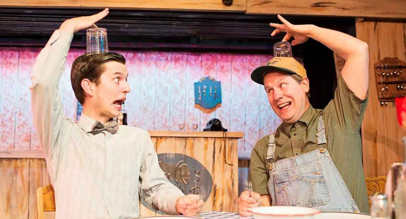 Two Playmill Theatre actors performing a comedy scene on stage at the Playmill Theatre Island Park Idaho